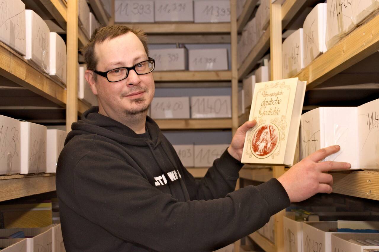»Machte-Buch«-Mitarbeiter Andrino Scharsig zwischen den Bücherregalen