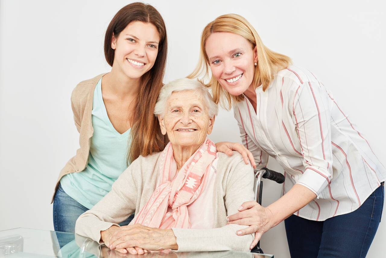 Zwei junge Frauen mit einer Seniorin