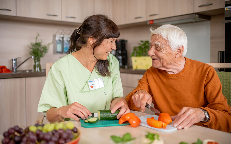 Bewohner und Betreuungskraft beim gemeinsamen Kochen